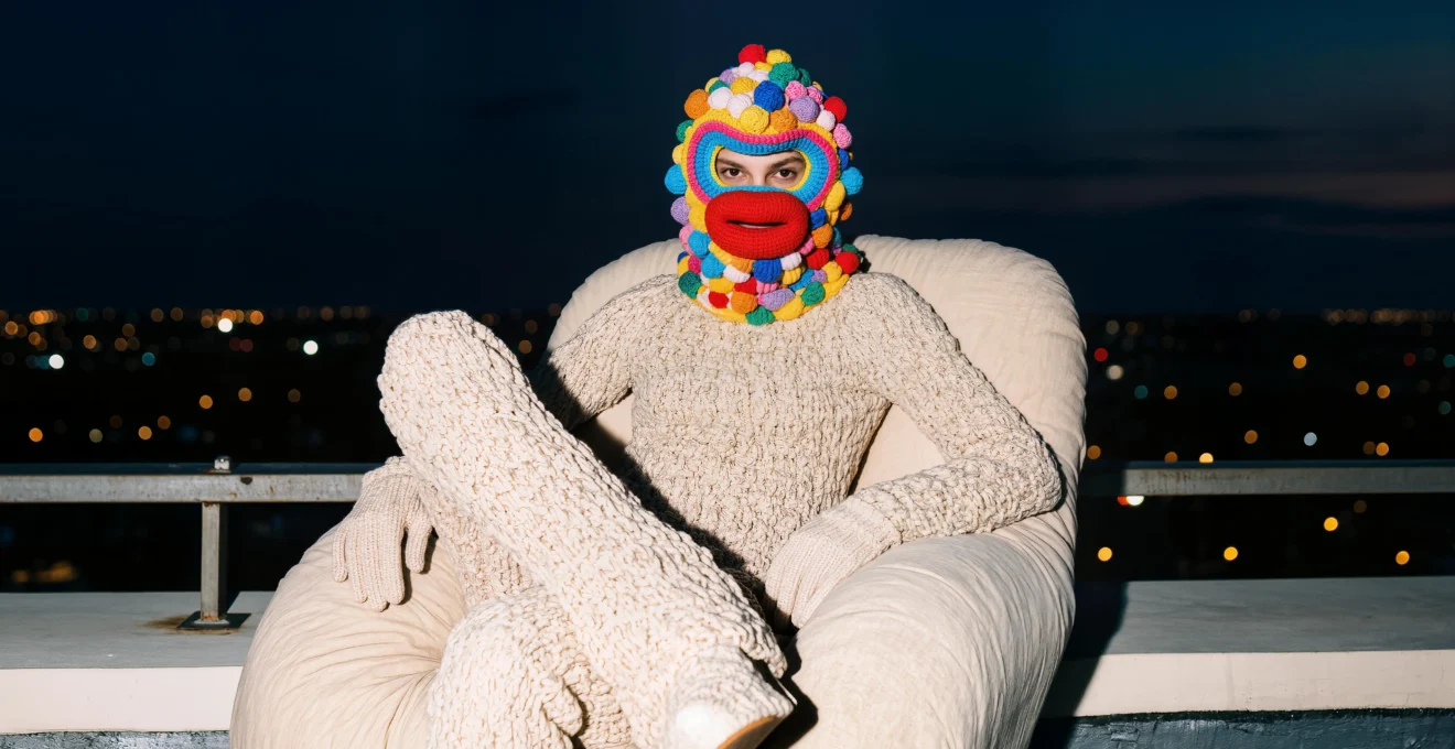 Des patineurs de dos et de profil glissent sur une surface brillante en extérieur, entourés de guirlandes hivernales floues